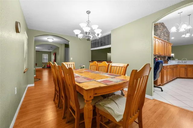 a room with wooden floors pool table and windows