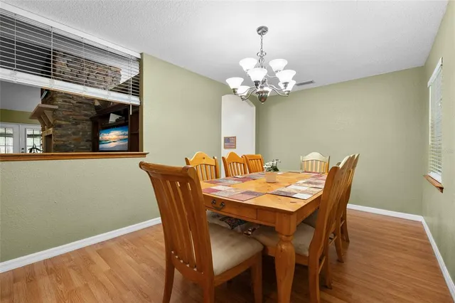 a room with wooden floors pool table and windows