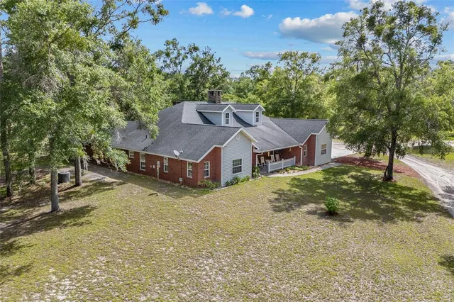 a front view of a house with a yard and trees