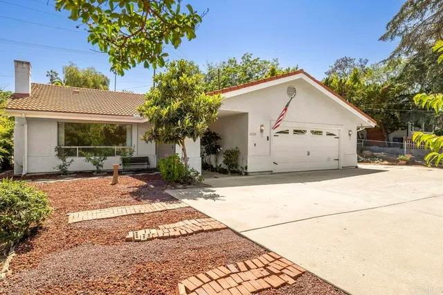 a view of a white house with a yard and potted plants