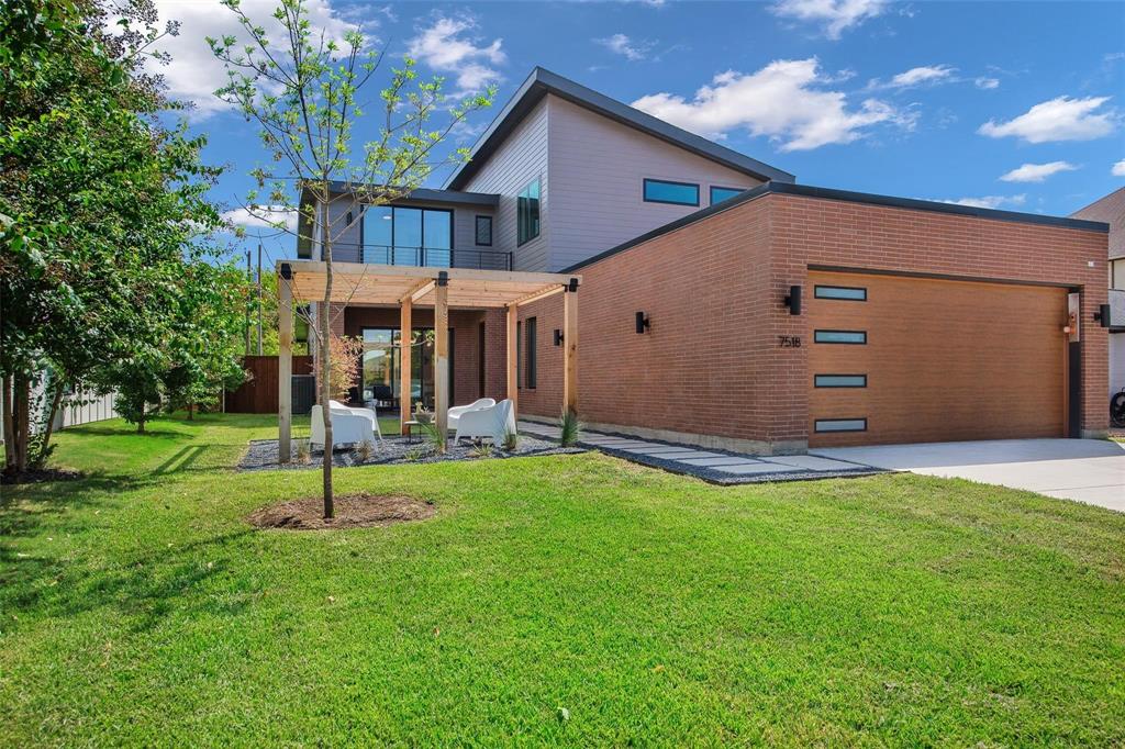 a view of a house with a backyard and a tree