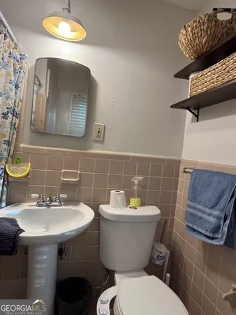 a bathroom with a sink mirror and toilet