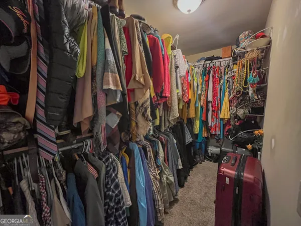 a view of walk in closet with clothes