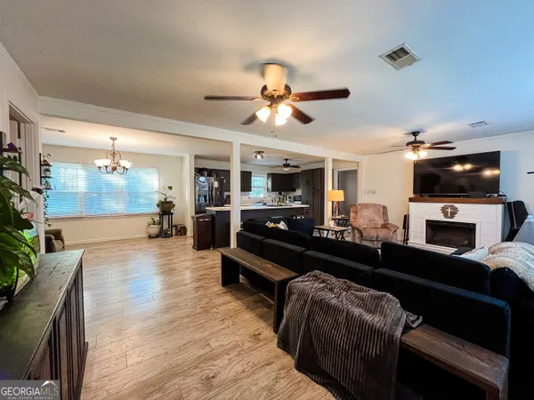 a living room with furniture a flat screen tv and kitchen view