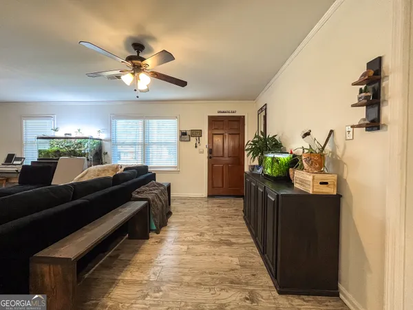 a living room with stainless steel appliances kitchen island granite countertop furniture and a chandelier