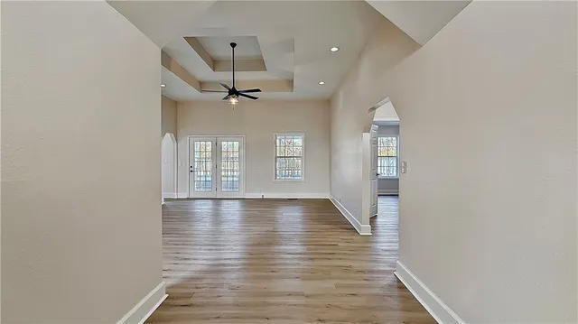 a view of an empty room with a window and wooden floor