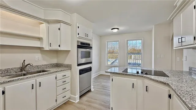 a kitchen with granite countertop a sink and cabinets