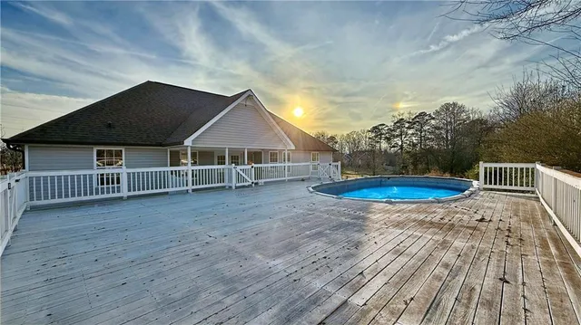 a view of a house with wooden deck and backyard