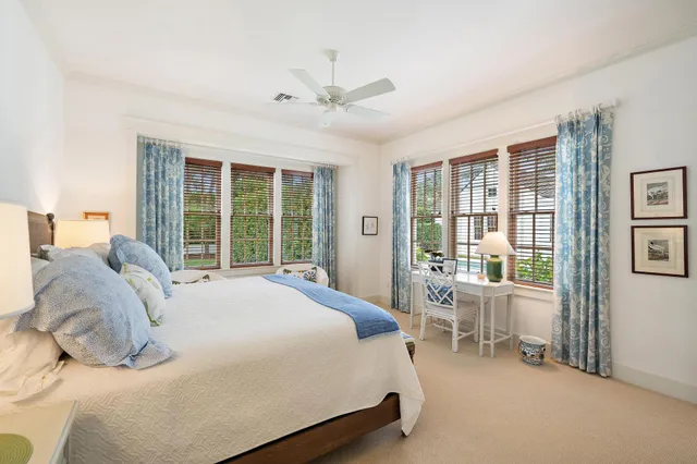 a bedroom with a large bed and windows