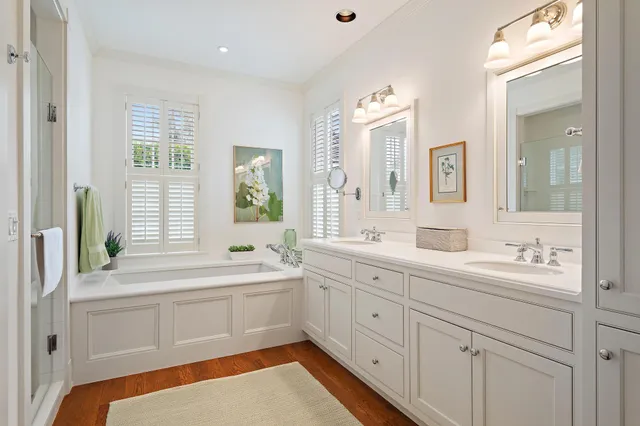 a bathroom with a sink a large mirror a vanity and next to a window
