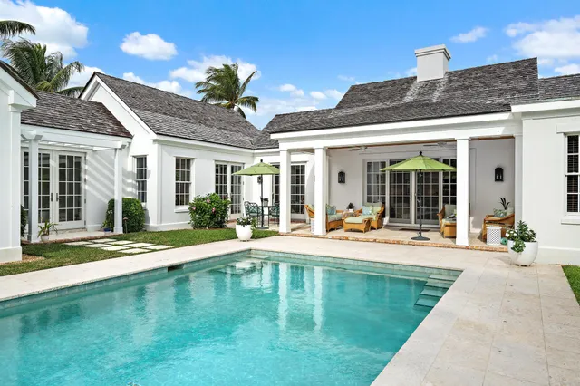 a house view with swimming pool in front of it