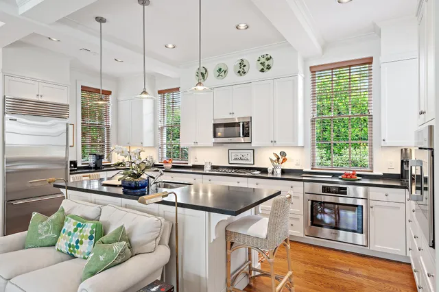 a kitchen with stainless steel appliances a stove a sink a stove and white cabinets