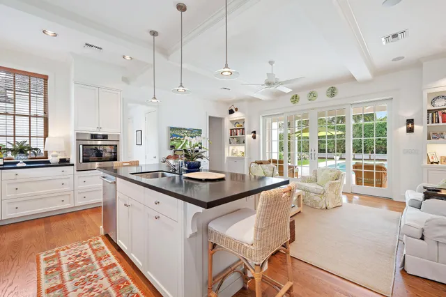 a kitchen with stainless steel appliances kitchen island granite countertop a stove and white cabinets