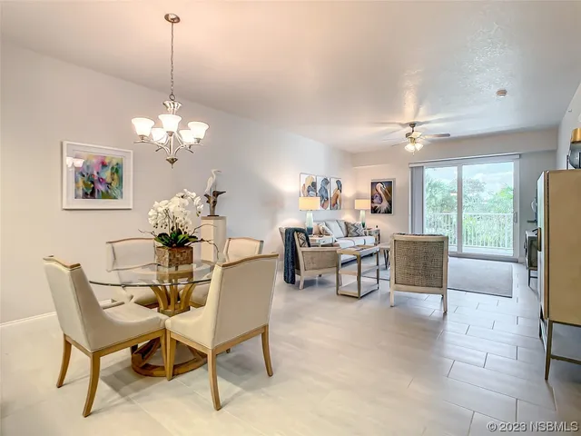a dining room with furniture a chandelier and wooden floor
