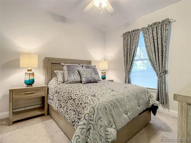 a bedroom with a bed and a lamp on dresser