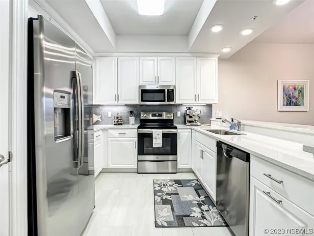 a kitchen with stainless steel appliances granite countertop a refrigerator stove and sink
