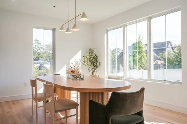 a dining room with furniture a chandelier and wooden floor