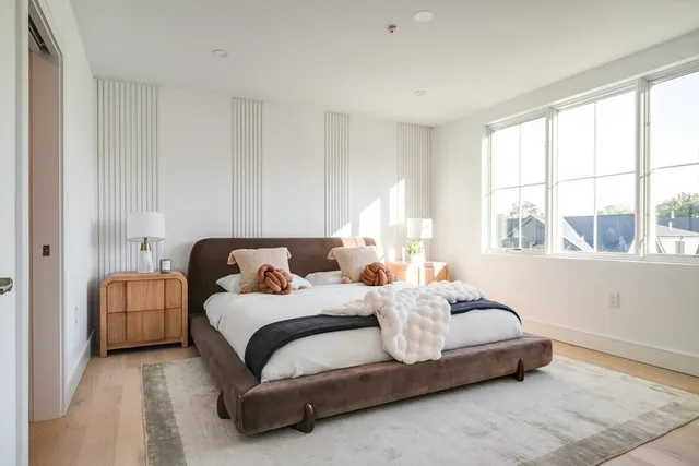 a bedroom with bed and a large window