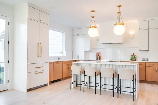 a kitchen with white cabinets and sink