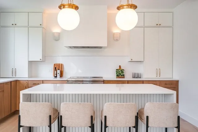 a kitchen with a dining table chairs and white cabinets