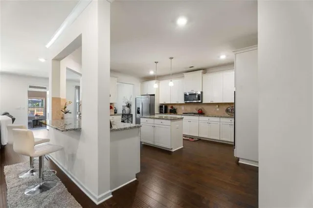 a kitchen with white cabinets and refrigerator