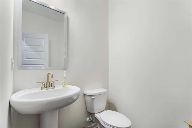 a bathroom with a sink a toilet and mirror