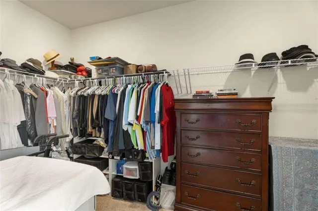 a view of walk in closet with clothes