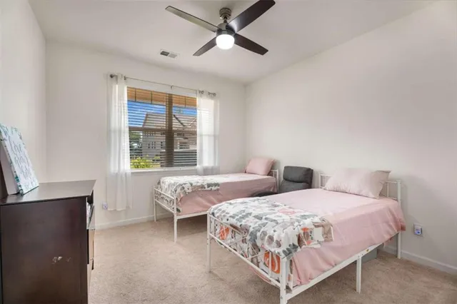 a bedroom with two beds and window