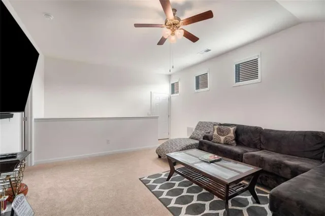 a living room with furniture a flat screen tv and a window