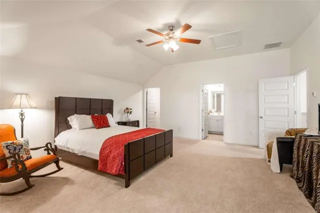 a spacious bedroom with a bed and ceiling fan