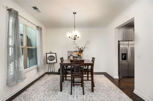 a dining room with furniture a chandelier and wooden floor