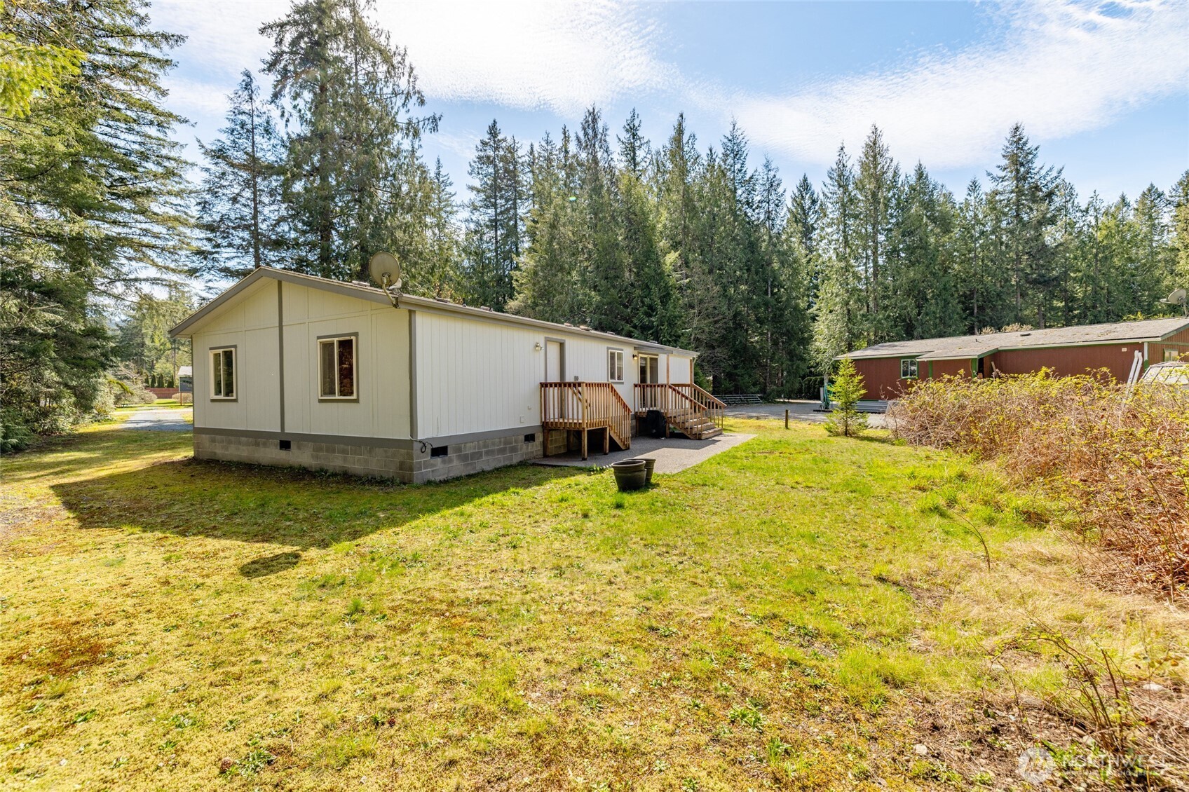 42041 Cedar Street Concrete, WA 98237 - Photo 30 of 33 a view of a white house with a large pool and lawn chairs under an umbrella