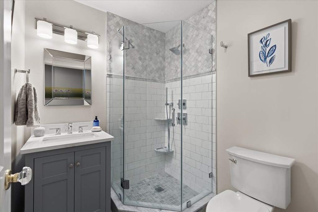 923 Lagrange Street, Unit 923 Boston, MA 02132 - Photo 27 of 32 a bathroom with a shower sink vanity and mirror