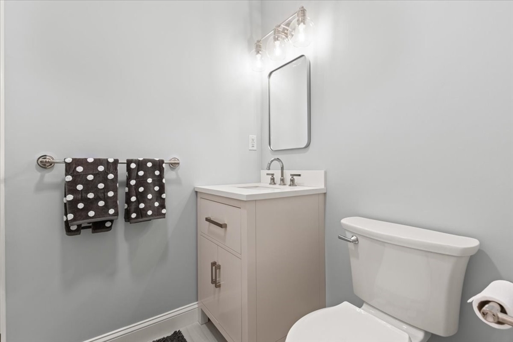 923 Lagrange Street, Unit 923 Boston, MA 02132 - Photo 8 of 32 a bathroom with a toilet sink and mirror