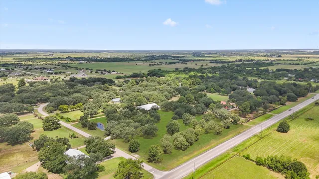an aerial view of residential houses with outdoor space and trees
