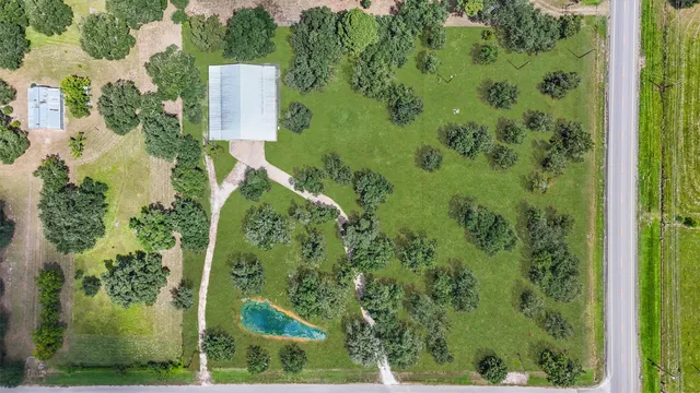an aerial view of a residential houses with yard