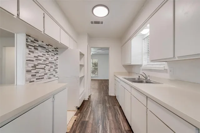 a kitchen with granite countertop a sink and cabinets