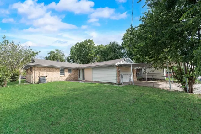 a view of a yard in front of a house with large trees