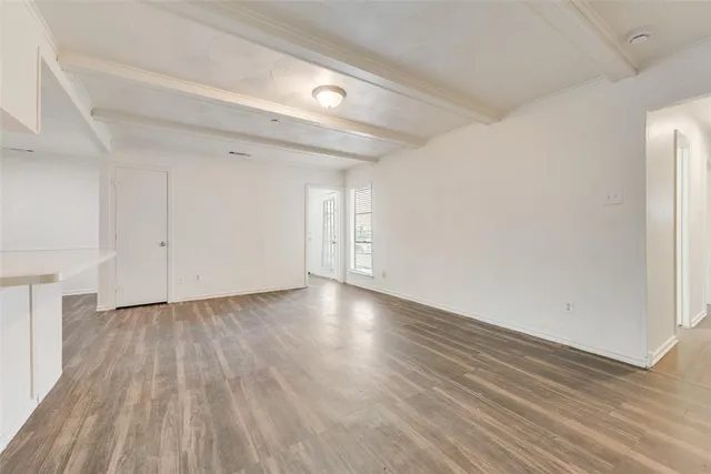 a view of a room with wooden floor and white walls