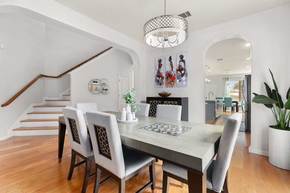 701 Old Ravine Court Round Rock, TX 78665 - Photo 11 of 40 Dining room with light wood-type flooring, arched walkways, stairs, a chandelier, and recessed lighting