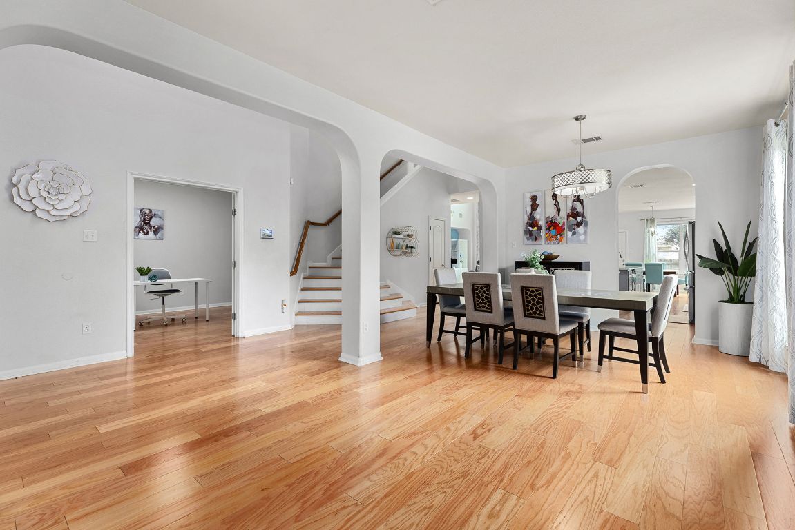 701 Old Ravine Court Round Rock, TX 78665 - Photo 12 of 40 Dining space with stairs, light wood-style floors, and arched walkways