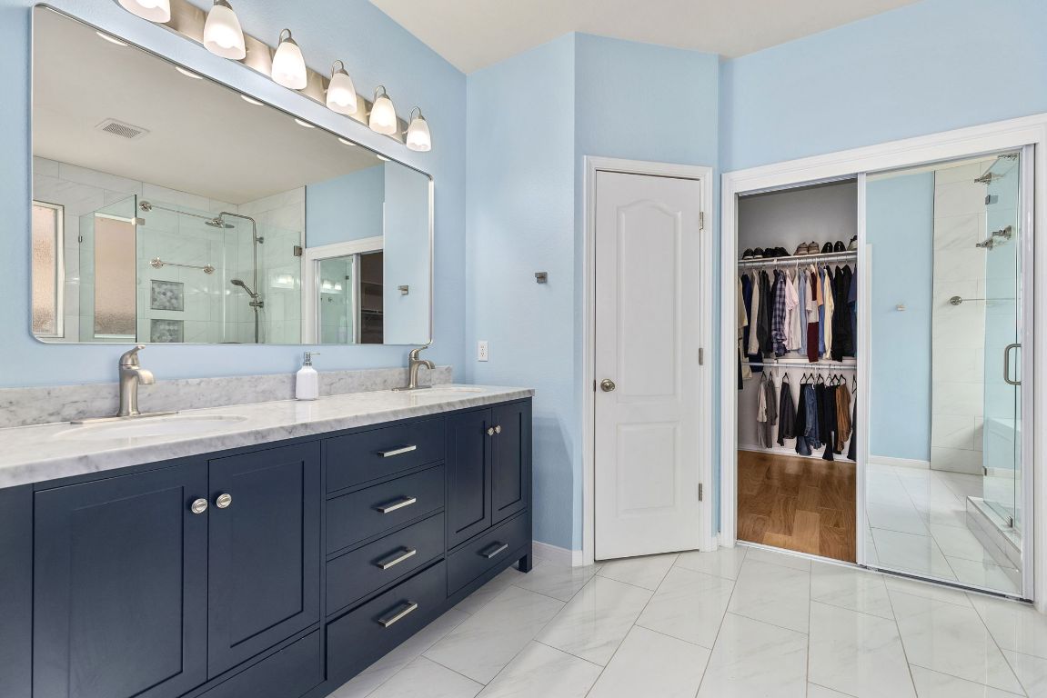 701 Old Ravine Court Round Rock, TX 78665 - Photo 17 of 40 Bathroom with a spacious closet, a shower stall, and double vanity