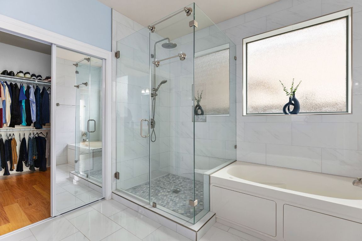 701 Old Ravine Court Round Rock, TX 78665 - Photo 18 of 40 Bathroom featuring a garden tub, a shower stall, a spacious closet, and tile patterned flooring