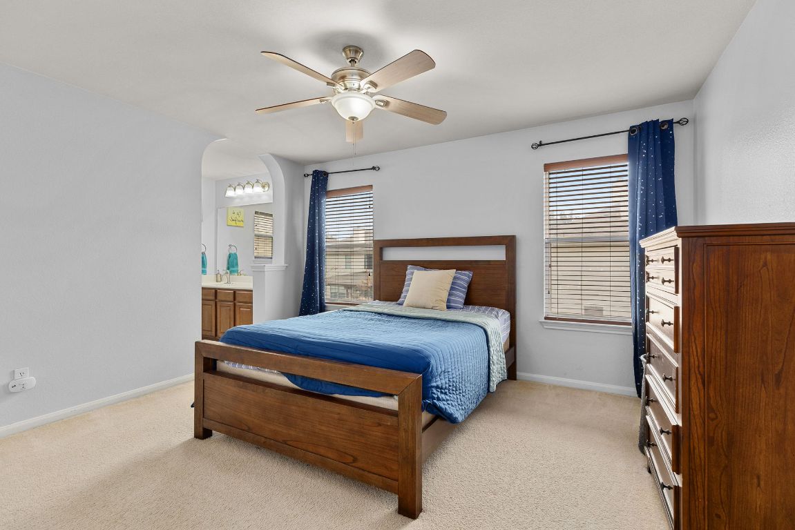 701 Old Ravine Court Round Rock, TX 78665 - Photo 23 of 40 Bedroom featuring light carpet, a ceiling fan, and ensuite bathroom