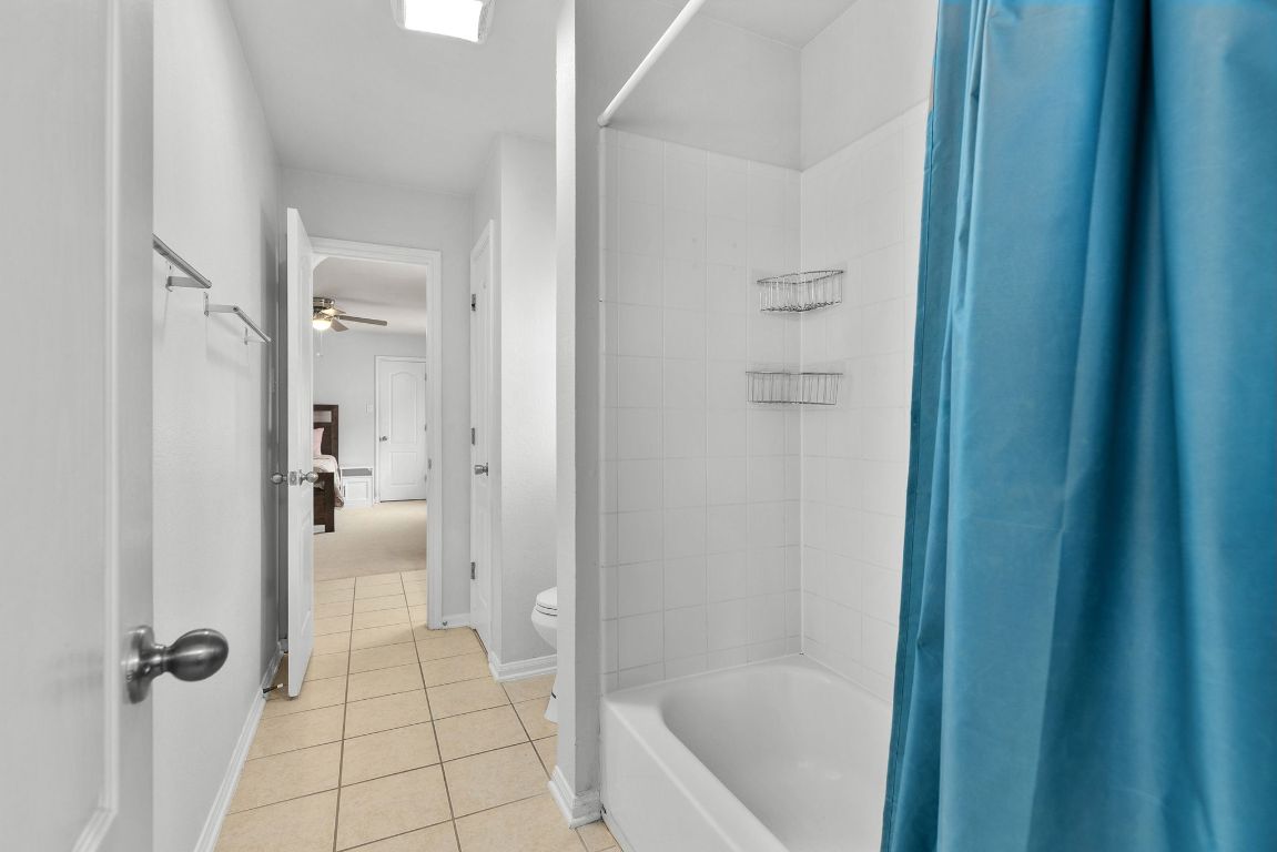 701 Old Ravine Court Round Rock, TX 78665 - Photo 25 of 40 Bathroom featuring shower / tub combo with curtain and light tile patterned flooring