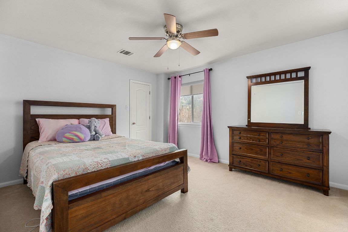 701 Old Ravine Court Round Rock, TX 78665 - Photo 27 of 40 Bedroom with light colored carpet and ceiling fan