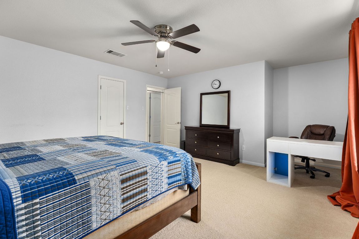 701 Old Ravine Court Round Rock, TX 78665 - Photo 31 of 40 Bedroom featuring carpet flooring, ceiling fan, and a desk
