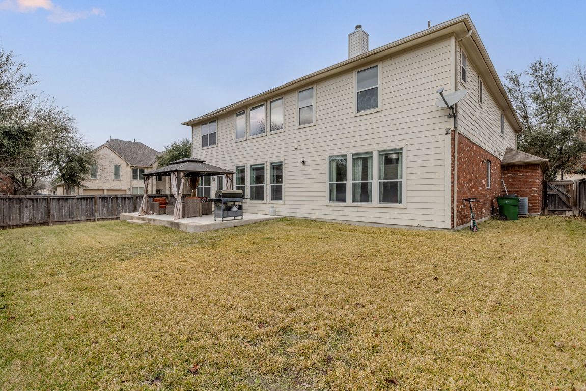701 Old Ravine Court Round Rock, TX 78665 - Photo 35 of 40 Rear view of property with a gazebo, a fenced backyard, a patio area, a chimney, and brick siding