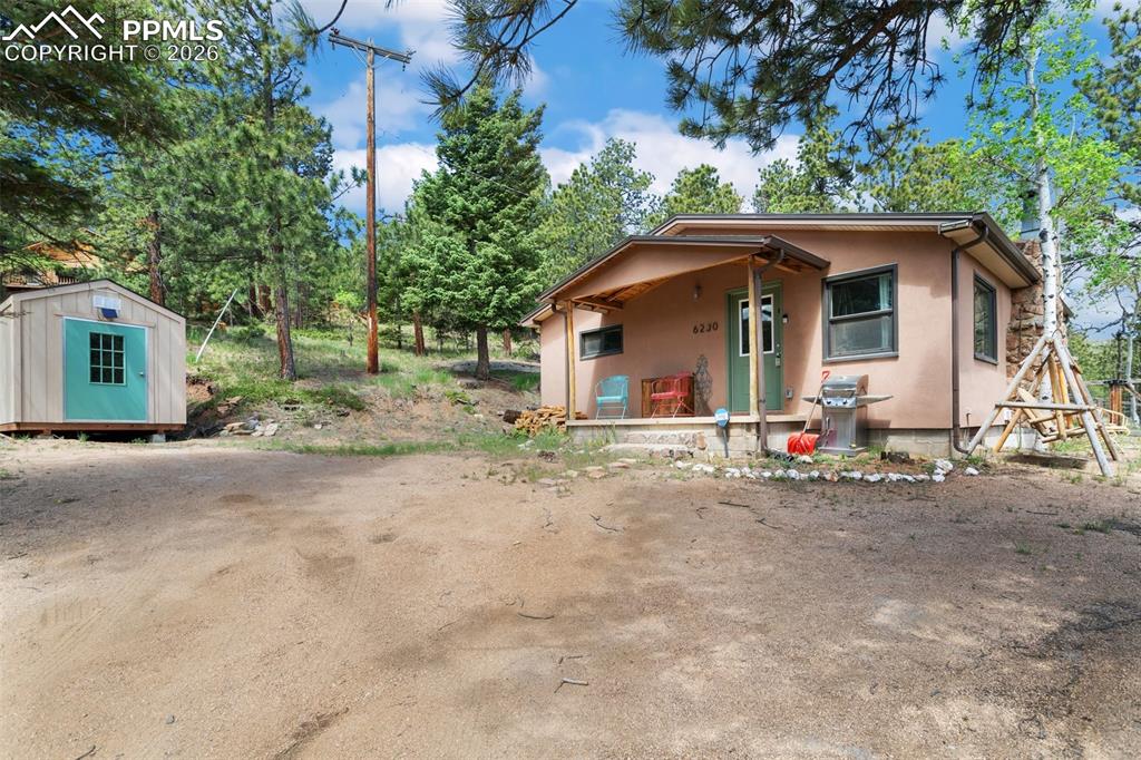 6230 Waterfall Loop Manitou Springs, CO 80829 - Photo 2 of 22 a view of a house with a yard and large trees