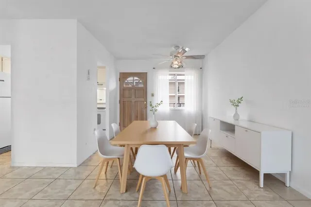 an empty room with kitchen and chandelier fan